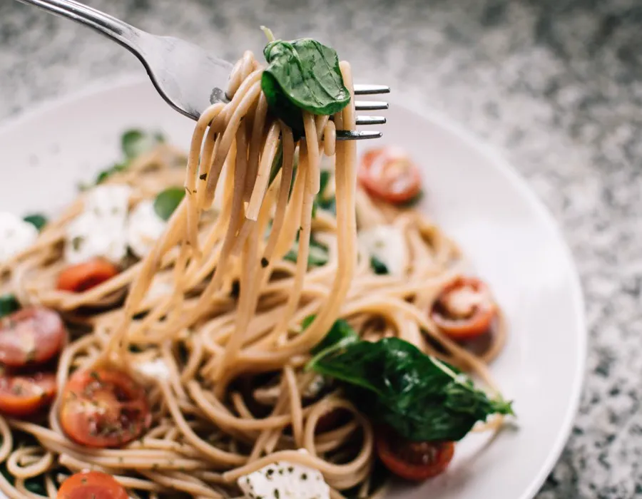 Plato de pasta con tomate emplatado en un restaurante